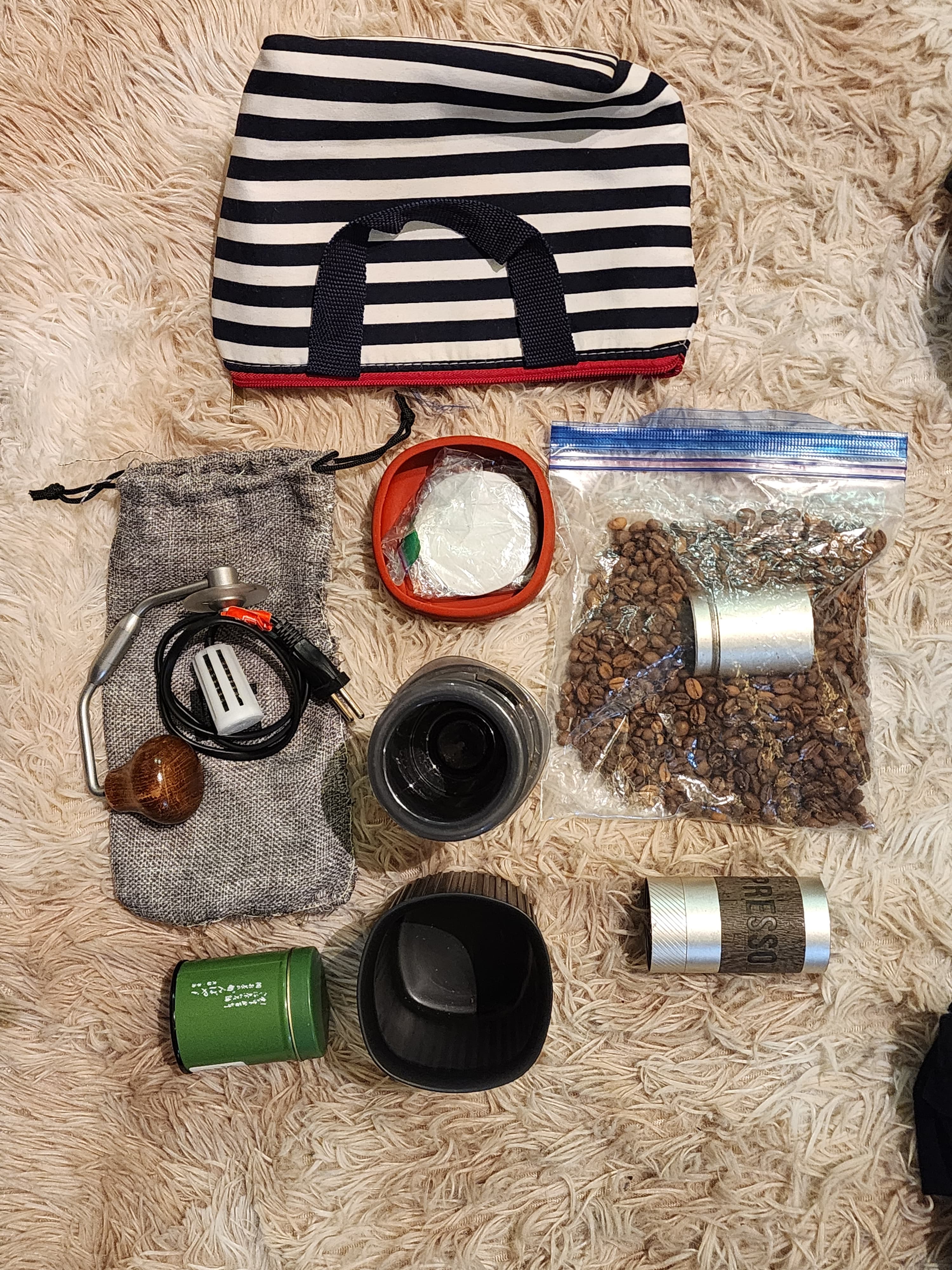 A compact tea and coffee travel kit arranged beside a blue-and-white striped Daiso pouch.